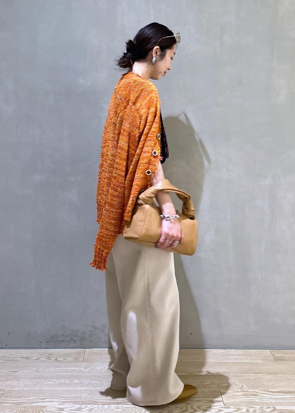 ベージュ系のハンドバッグ、ホワイト系のデニムパンツ、ホワイト系のTシャツ/カットソーを着用したレディースの春コーディネートの5枚目の写真