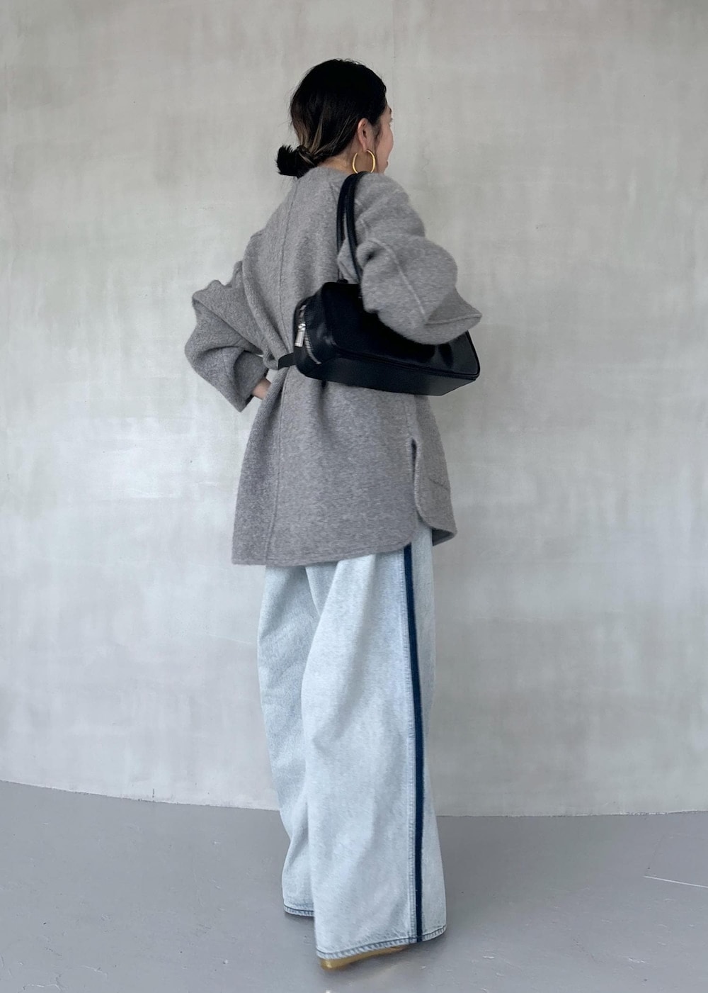 ゴールド系のパンプス、ブルー系のその他パンツ、ブラック系のボストンバッグを着用したレディースの秋コーディネートの5枚目の写真