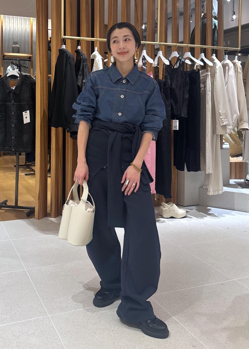 ブラック系のローファー、ホワイト系のハンドバッグ、ブルー系のブルゾンを着用したレディースの春コーディネートの6枚目の写真