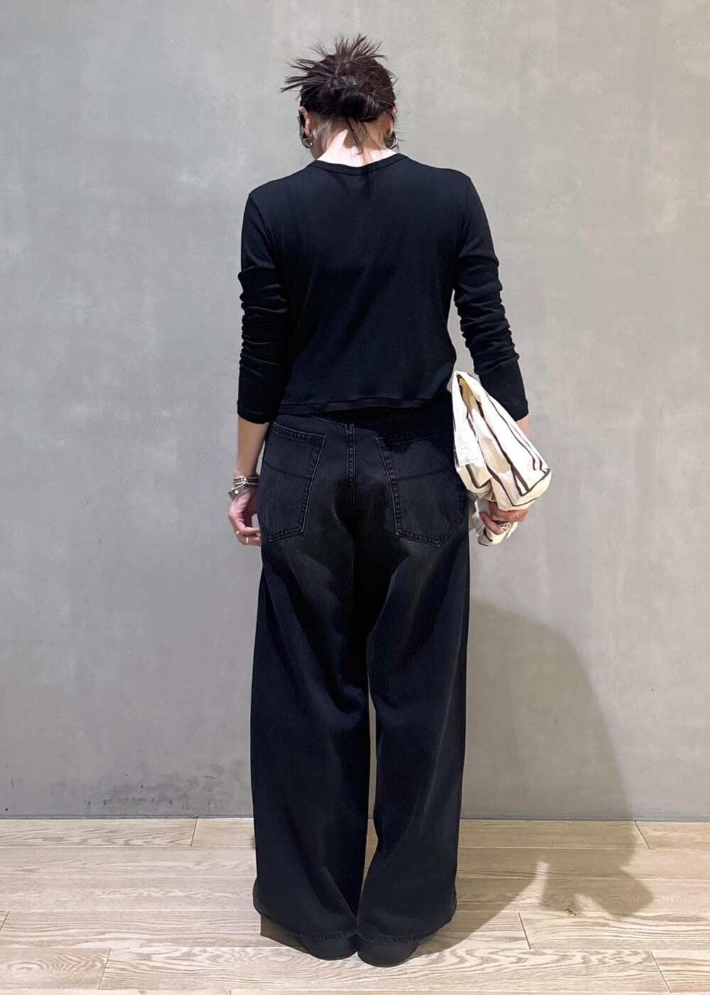 ブラック系のカーディガン/ボレロ、ホワイト系のショルダーバッグ、ブラック系のデニムパンツを着用したレディースの春コーディネートの3枚目の写真