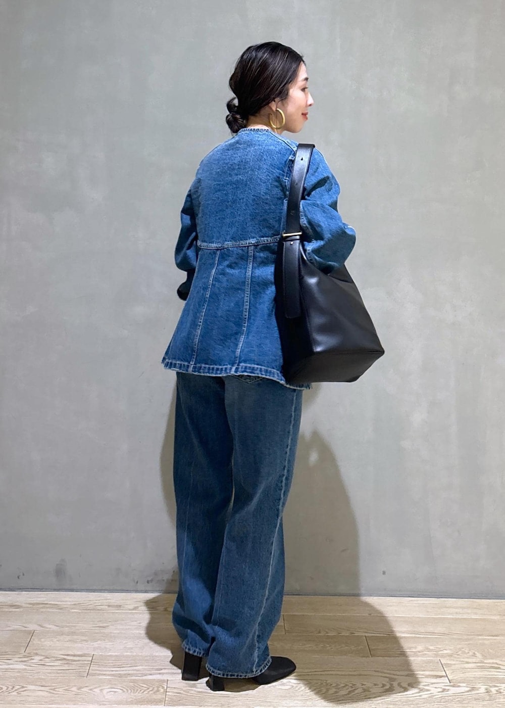 ブルー系のシャツ/ブラウス、ブルー系のデニムパンツ、ブラック系のショルダーバッグを着用したレディースの冬コーディネートの6枚目の写真