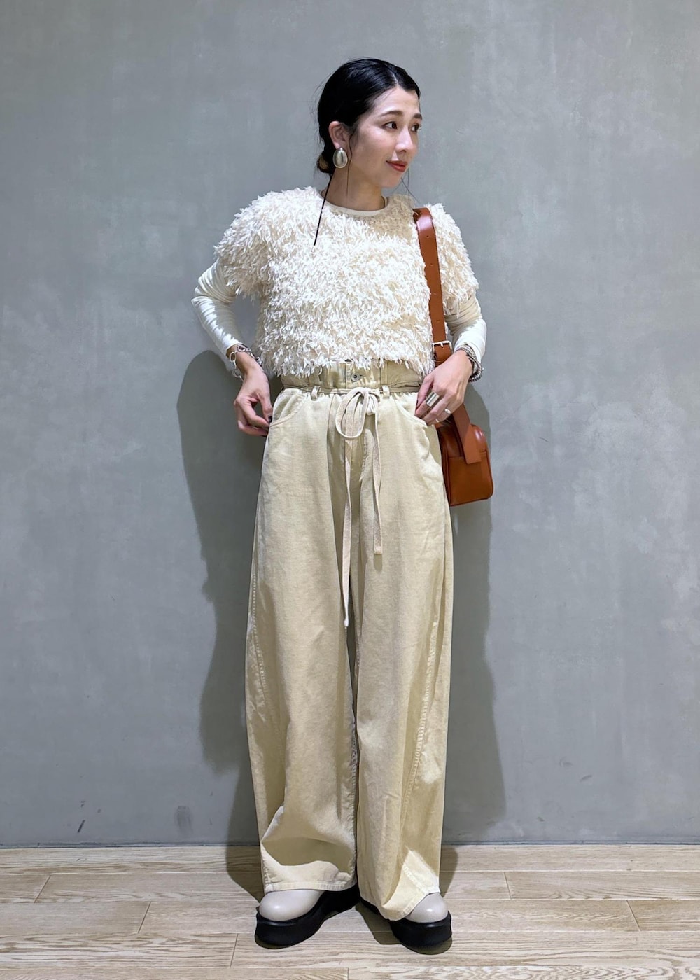 ホワイト系のTシャツ/カットソー、ベージュ系のサンダル、ブラウン系のショルダーバッグを着用したレディースの夏コーディネートの3枚目の写真