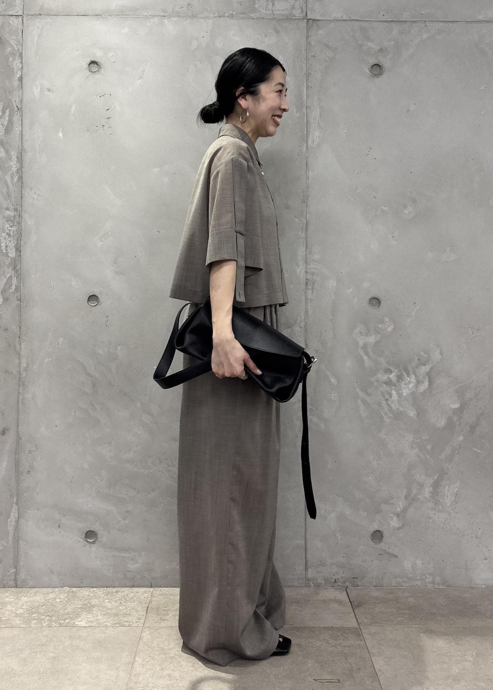 ブラック系のサンダル、ベージュ系のシャツ/ブラウス、ベージュ系のスラックスを着用したレディースの春コーディネートの5枚目の写真