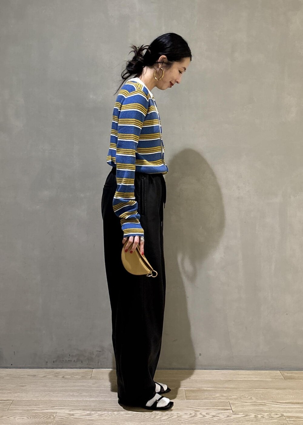 ブルー系のポロシャツ、ブラック系のその他パンツ、イエロー系のキーホルダーを着用したレディースの秋コーディネートの4枚目の写真