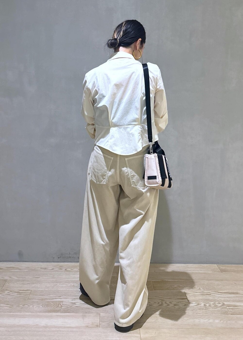 ベージュ系のトートバッグ、ベージュ系のその他パンツ、ブラック系のスニーカーを着用したレディースの秋コーディネートの5枚目の写真