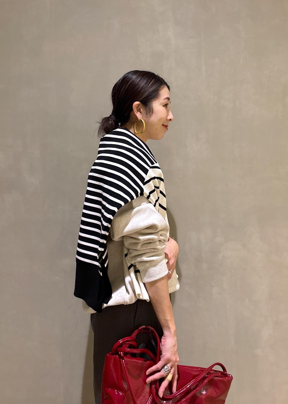 グレー系のスラックス、ホワイト系のスウェット、ブラック系のニット/セーターを着用したレディースの冬コーディネートの9枚目の写真