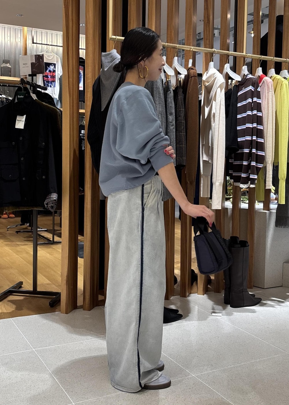 ブルー系のデニムパンツ、ブルー系のショルダーバッグ、ブルー系のスウェットを着用したレディースの秋コーディネートの4枚目の写真