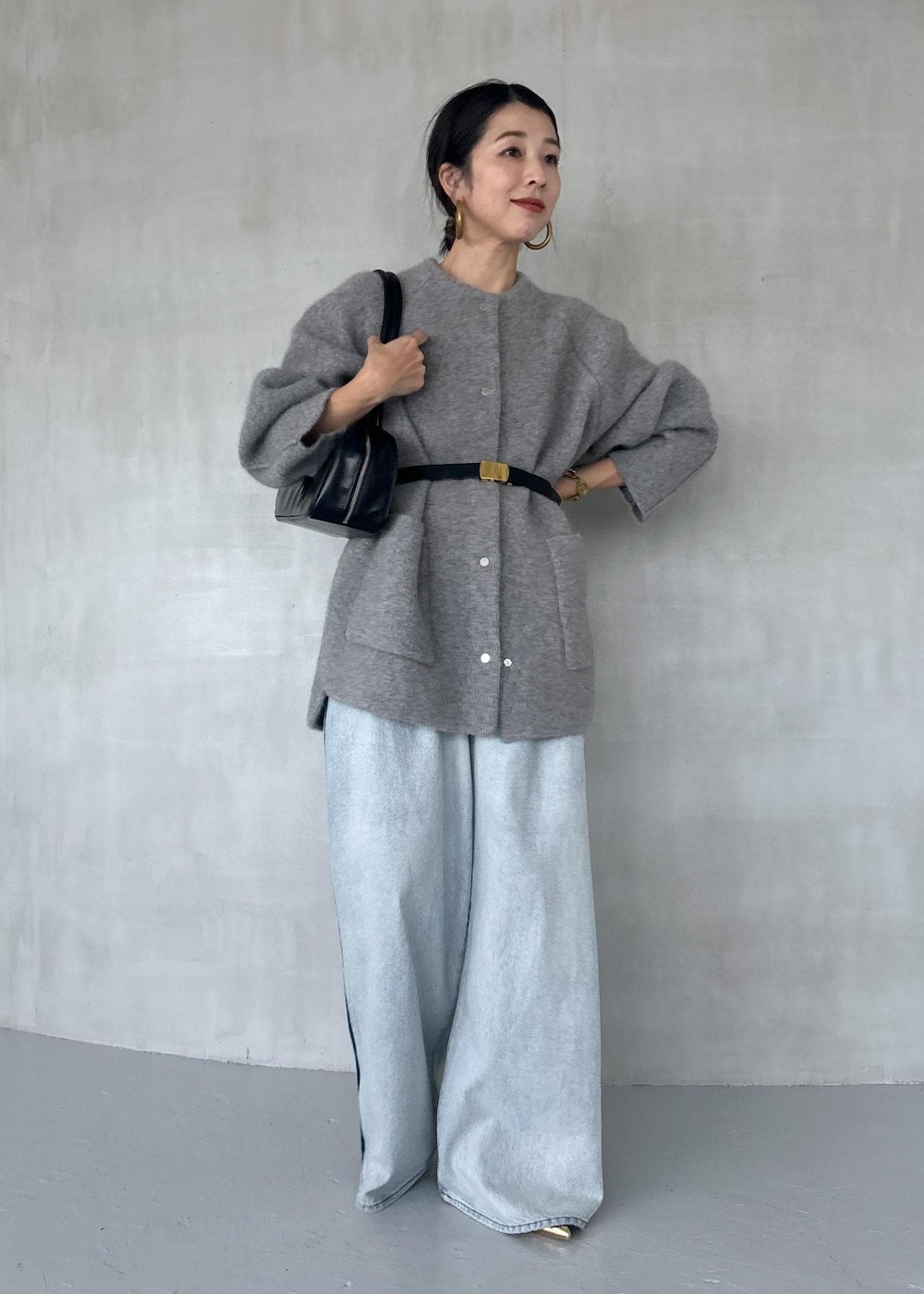 ゴールド系のパンプス、ブルー系のその他パンツ、ブラック系のボストンバッグを着用したレディースの秋コーディネートの3枚目の写真