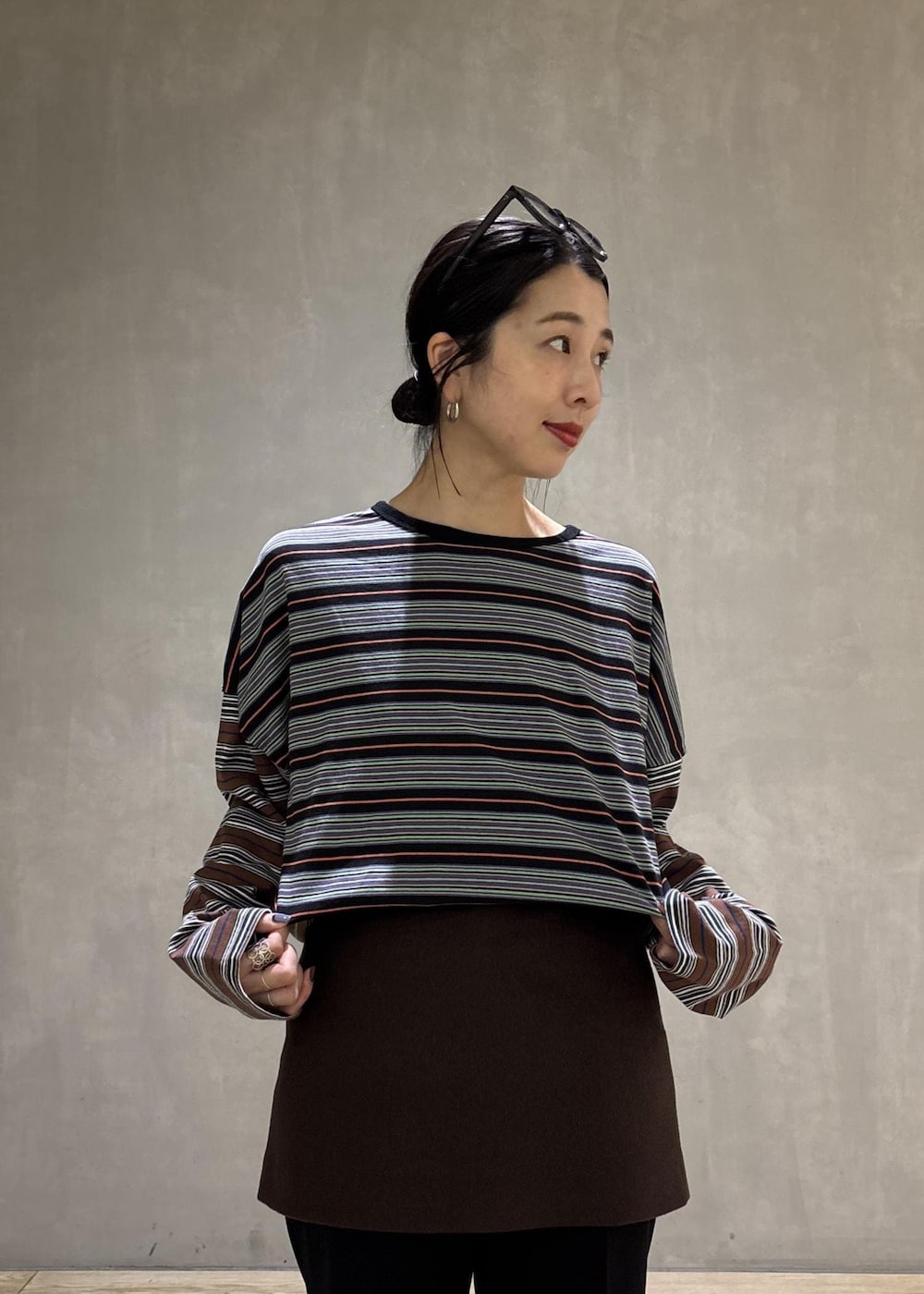 ブラック系のスラックス、ブラウン系のスカート、ブラック系のTシャツ/カットソーを着用したレディースの秋コーディネートの9枚目の写真