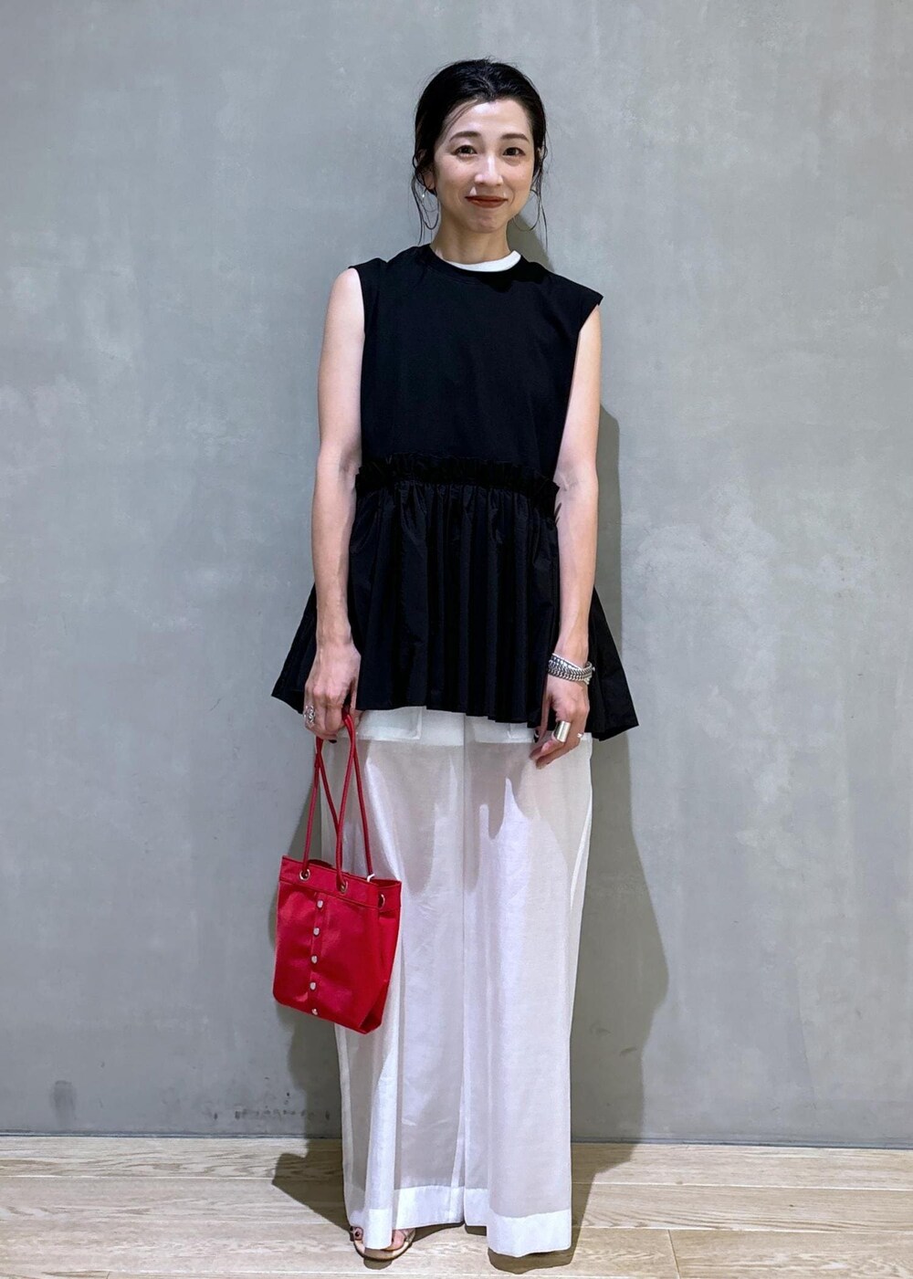 ホワイト系のタンクトップ、ホワイト系のその他パンツ、レッド系のハンドバッグを着用したレディースの夏コーディネートの2枚目の写真