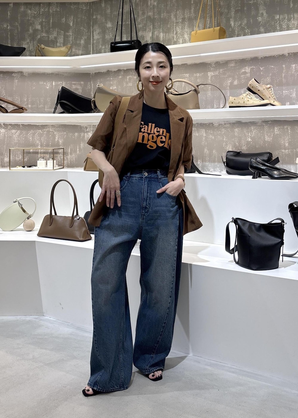 イエロー系のテーラードジャケット、ブルー系のデニムパンツ、ブラック系のTシャツ/カットソーを着用したレディースの春コーディネートの5枚目の写真