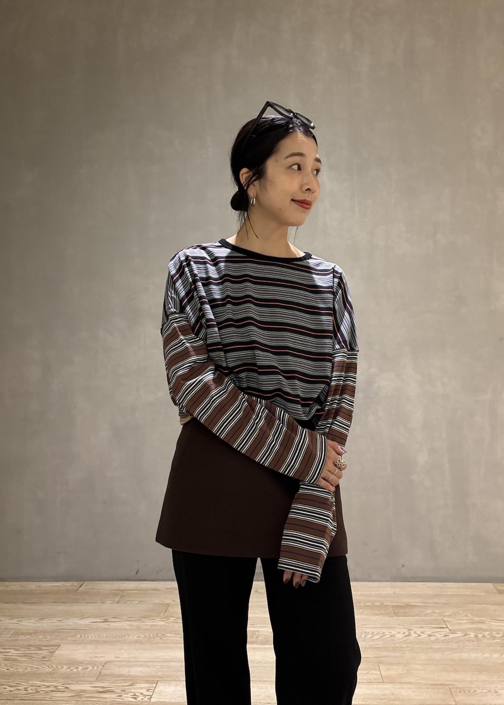 ブラック系のスラックス、ブラウン系のスカート、ブラック系のTシャツ/カットソーを着用したレディースの秋コーディネートの6枚目の写真
