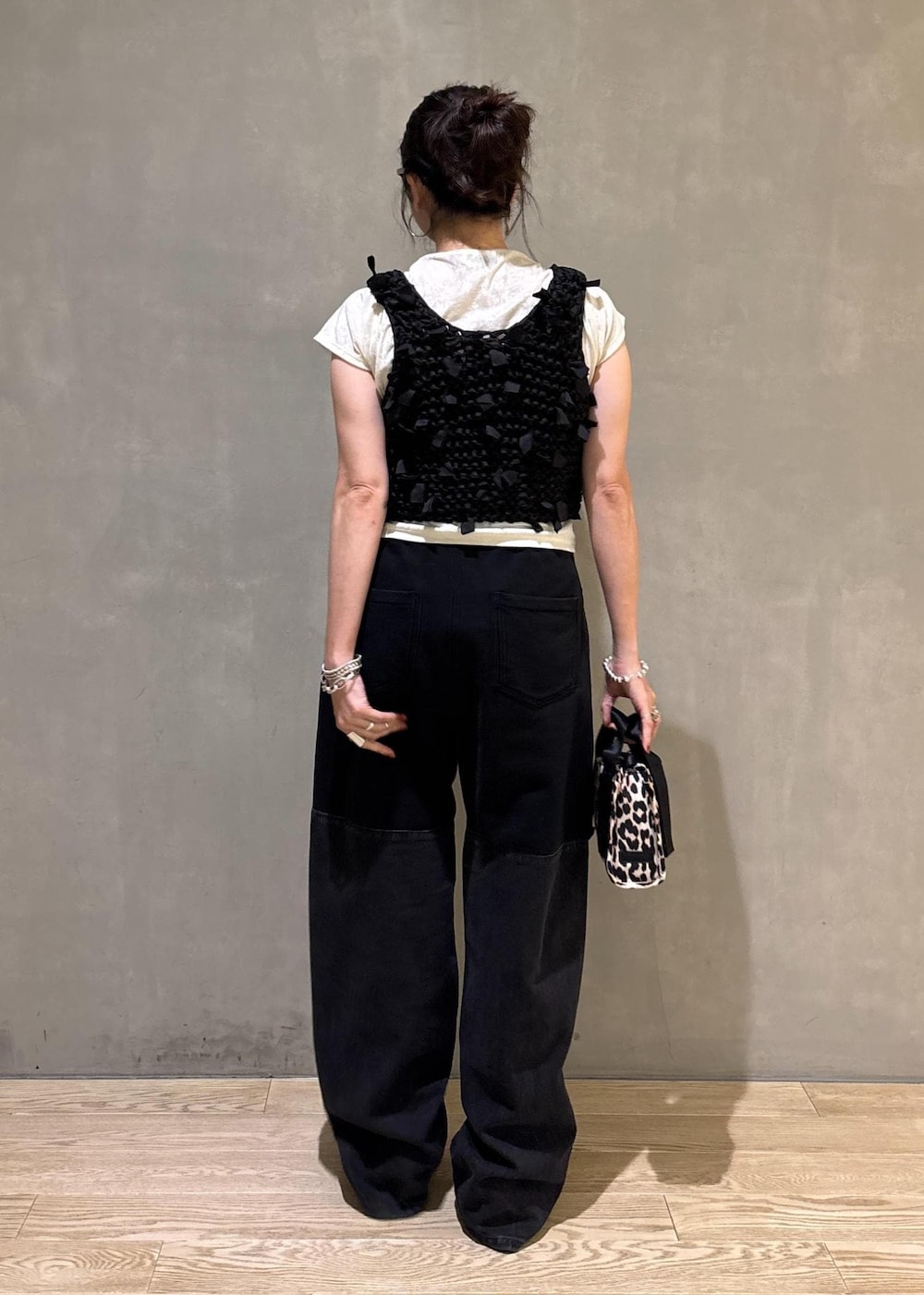 ホワイト系のTシャツ/カットソー、ベージュ系のショルダーバッグ、ブラック系のベストを着用したレディースの夏コーディネートの4枚目の写真