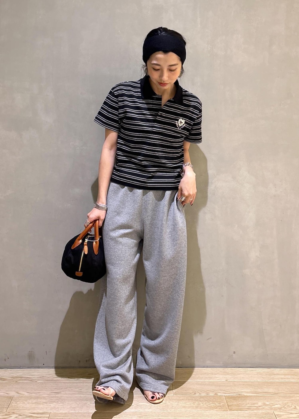 グレー系のスウェットパンツ、ブラック系のポロシャツを着用したレディースの夏コーディネートの7枚目の写真