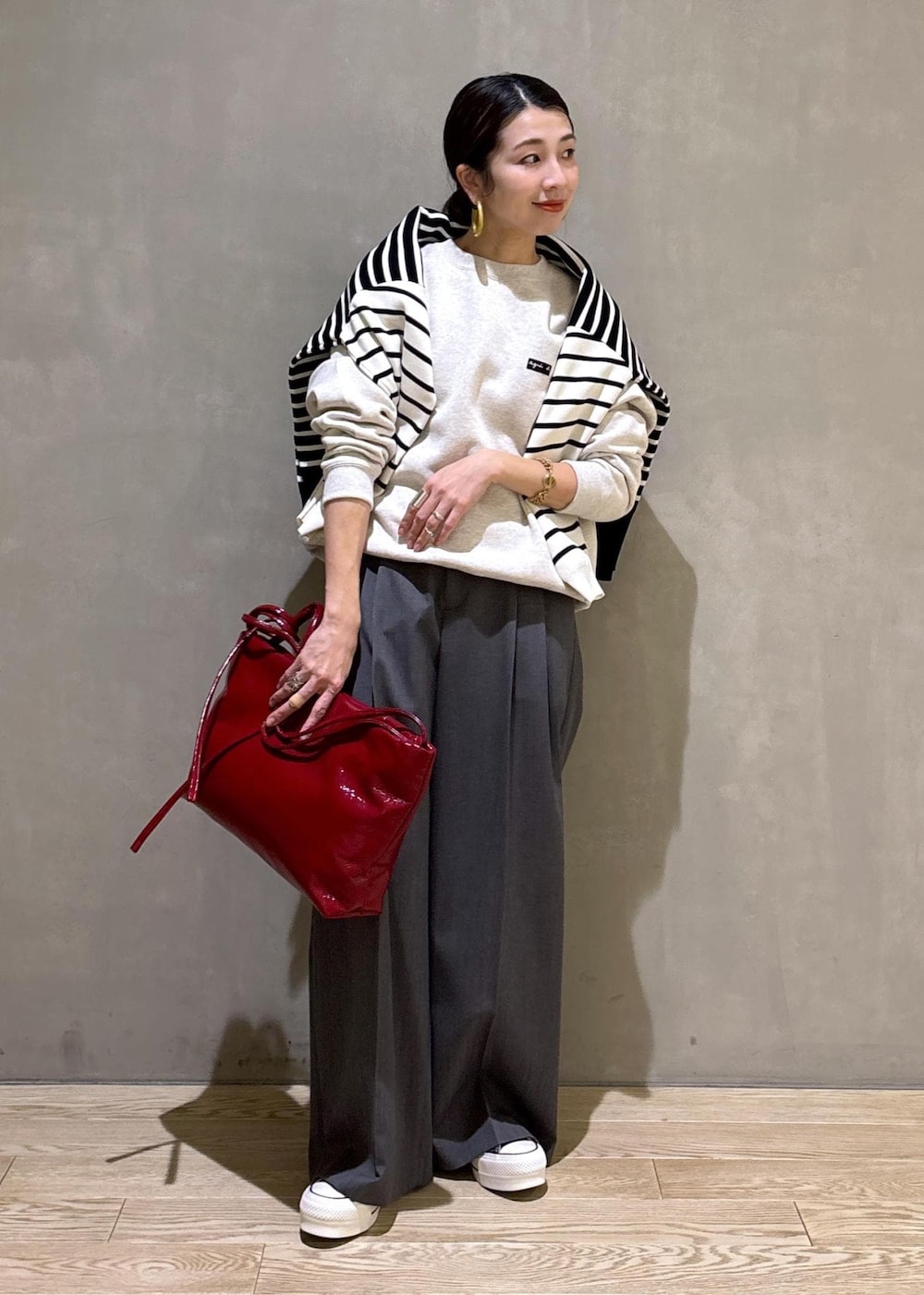 グレー系のスラックス、ホワイト系のスウェット、ブラック系のニット/セーターを着用したレディースの冬コーディネートの7枚目の写真