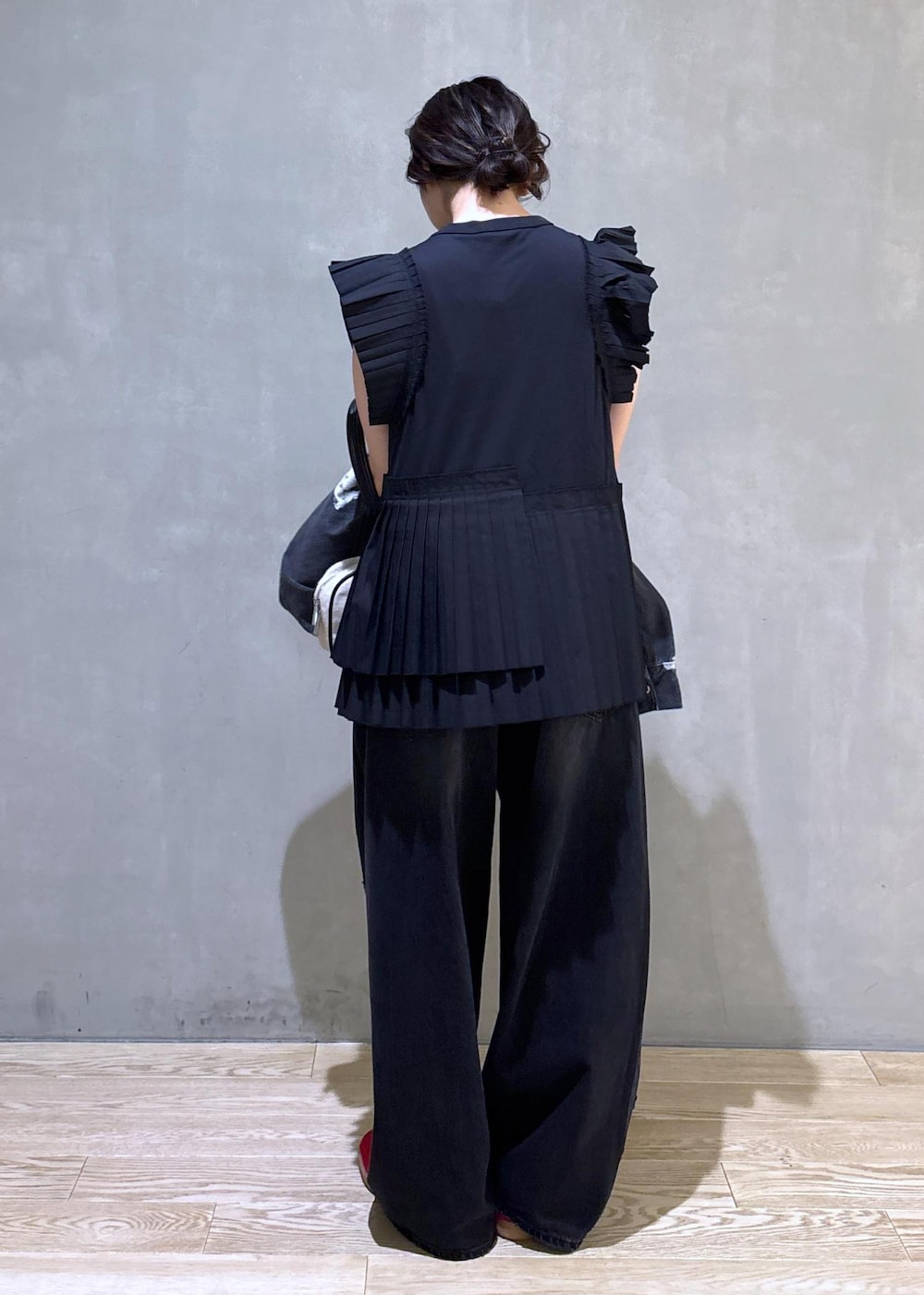 ブラック系のTシャツ/カットソー、ブラック系のデニムパンツ、ホワイト系のボストンバッグを着用したレディースの春コーディネートの5枚目の写真