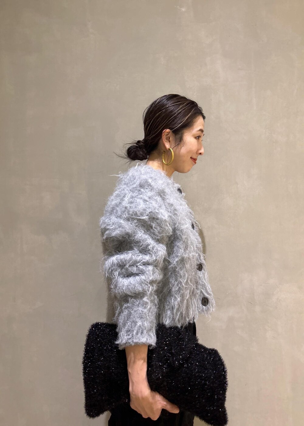 ブラック系のスカート、グレー系のカーディガン/ボレロ、ブラック系のトートバッグを着用したレディースの冬コーディネートの7枚目の写真