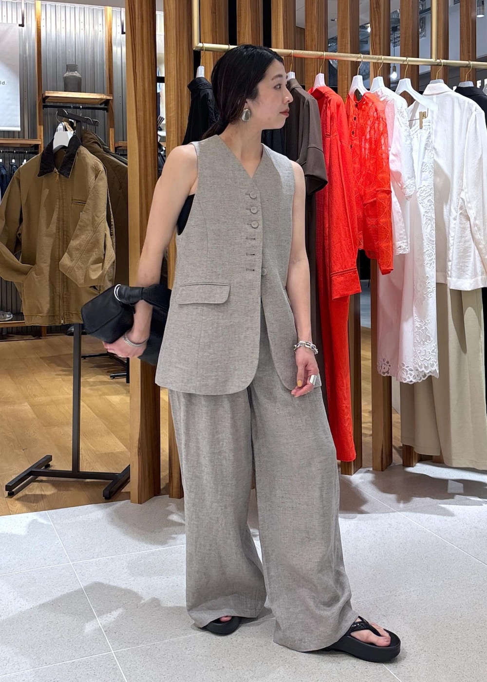 ブラック系のハンドバッグ、ベージュ系のその他パンツ、ベージュ系のベストを着用したレディースの春コーディネートの2枚目の写真