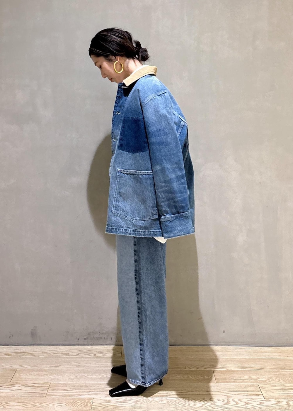 ホワイト系のハンドバッグ、ブルー系のデニムパンツ、ブルー系のデニムジャケットを着用したレディースの冬コーディネートの7枚目の写真