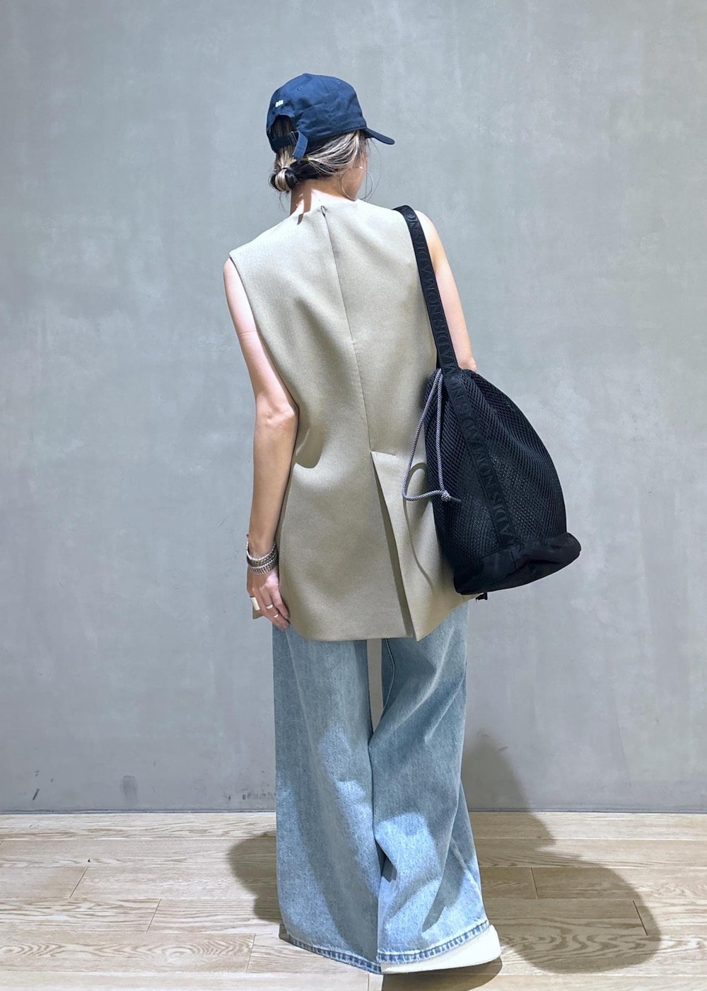 ベージュ系のベスト、ブラック系のスニーカー、ブラック系のショルダーバッグを着用したレディースの夏コーディネートの6枚目の写真