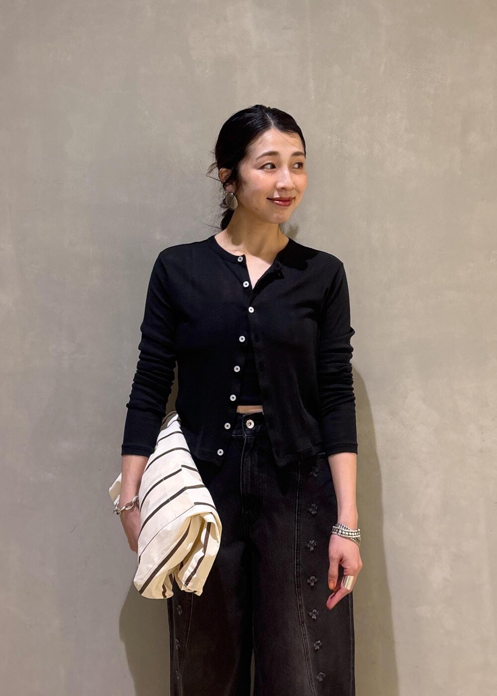 ブラック系のカーディガン/ボレロ、ホワイト系のショルダーバッグ、ブラック系のデニムパンツを着用したレディースの春コーディネートの8枚目の写真