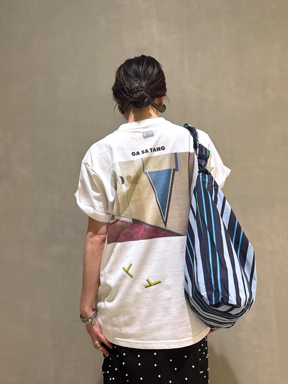 ブルー系のデニムパンツ、ブルー系のショルダーバッグ、ホワイト系のTシャツ/カットソーを着用したレディースの春コーディネートの9枚目の写真