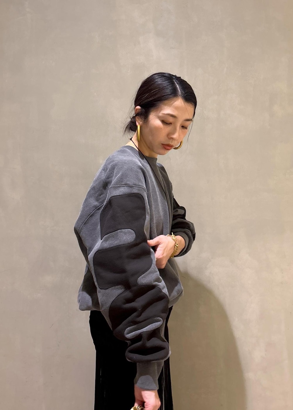 ブラック系のデニムパンツ、ブラック系のスカート、ベージュ系のポーチを着用したレディースの冬コーディネートの9枚目の写真