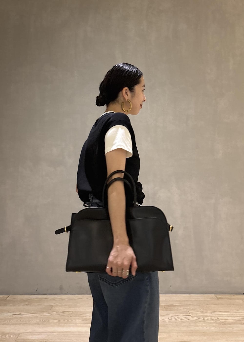 ブラック系のトートバッグ、ブラック系のTシャツ/カットソー、ブルー系のデニムパンツを着用したレディースの夏コーディネートの9枚目の写真