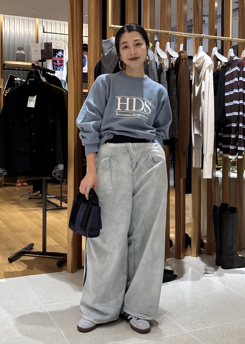 ブルー系のデニムパンツ、ブルー系のショルダーバッグ、ブルー系のスウェットを着用したレディースの秋コーディネートの2枚目の写真