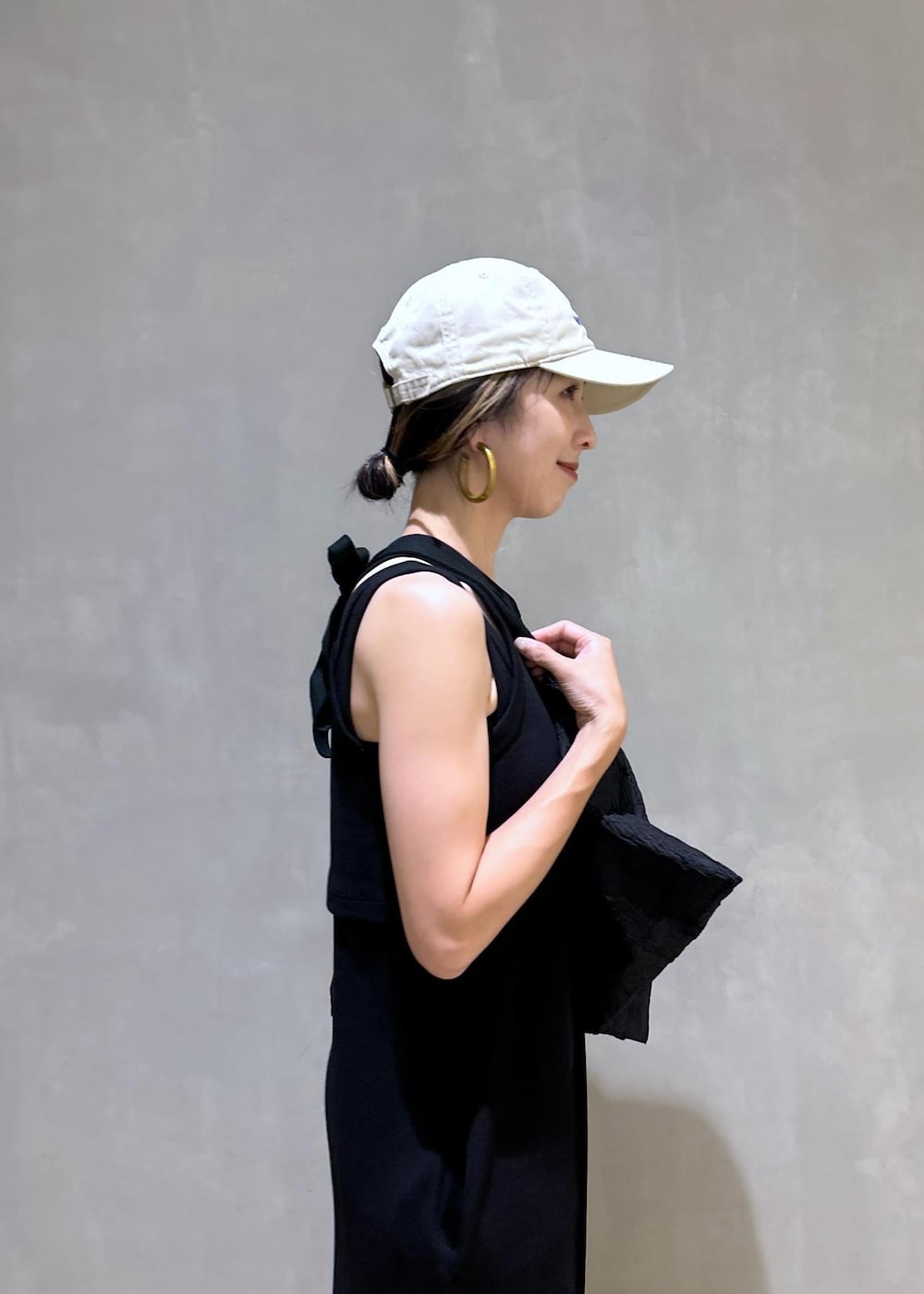 ブラック系のスニーカー、ブラック系のつなぎ/オールインワン、ベージュ系のキャップを着用したレディースの夏コーディネートの10枚目の写真