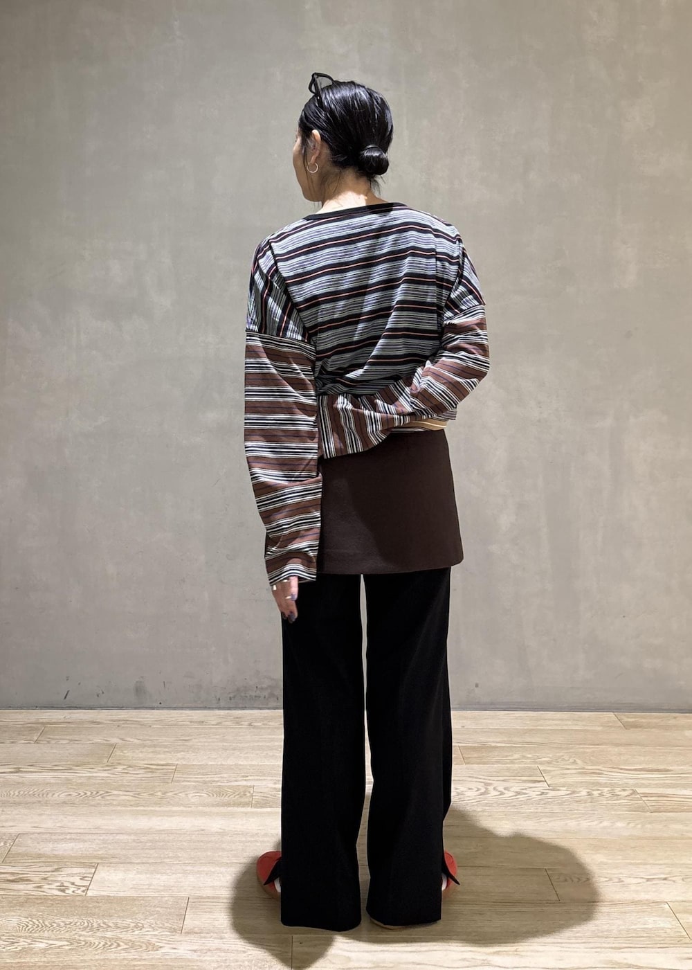 ブラック系のスラックス、ブラウン系のスカート、ブラック系のTシャツ/カットソーを着用したレディースの秋コーディネートの5枚目の写真