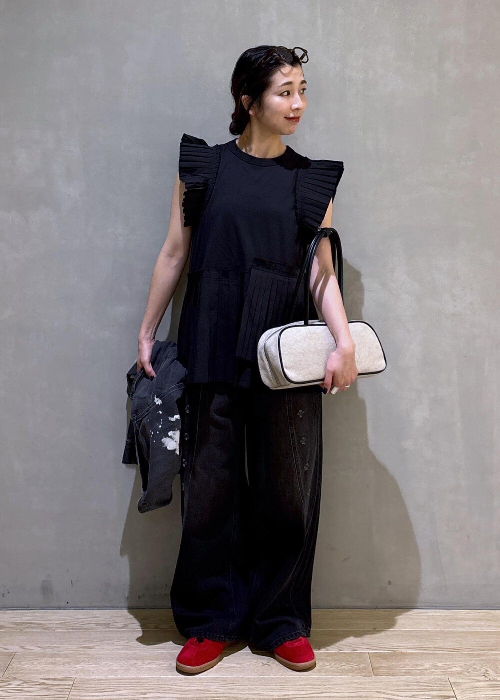 ブラック系のTシャツ/カットソー、ブラック系のデニムパンツ、ホワイト系のボストンバッグを着用したレディースの春コーディネートの7枚目の写真