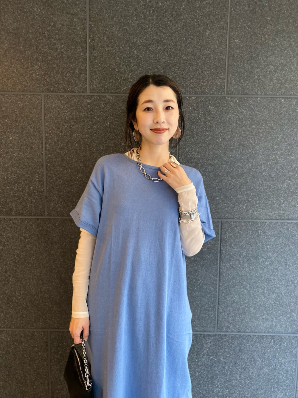 ブラック系のショルダーバッグ、ブルー系のワンピース/ドレス、ブラック系のサンダルを着用したレディースの春コーディネートの2枚目の写真