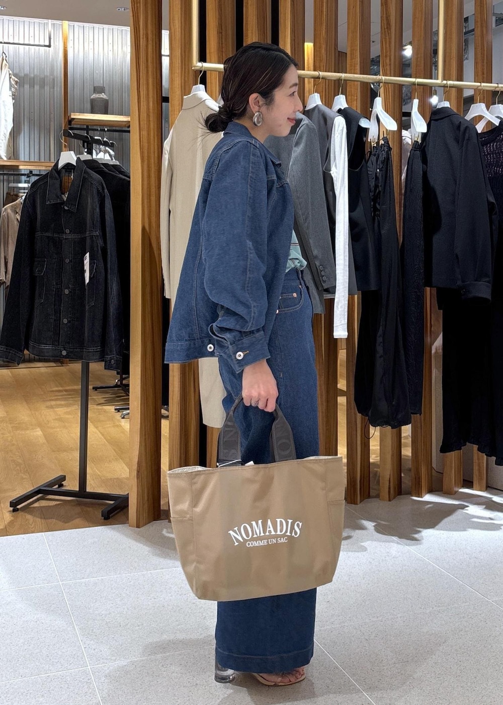 ベージュ系のハンドバッグ、ブルー系のTシャツ/カットソー、ブルー系のブルゾンを着用したレディースの冬コーディネートの7枚目の写真