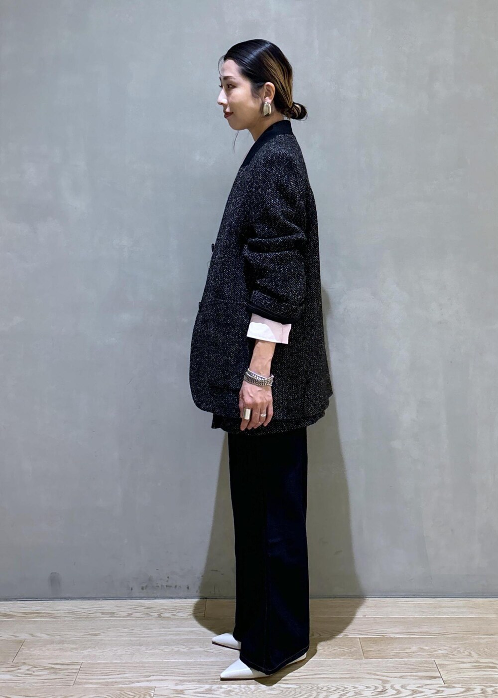 ブラック系のショルダーバッグ、ホワイト系のパンプス、ブルー系のデニムパンツを着用したレディースの夏コーディネートの6枚目の写真