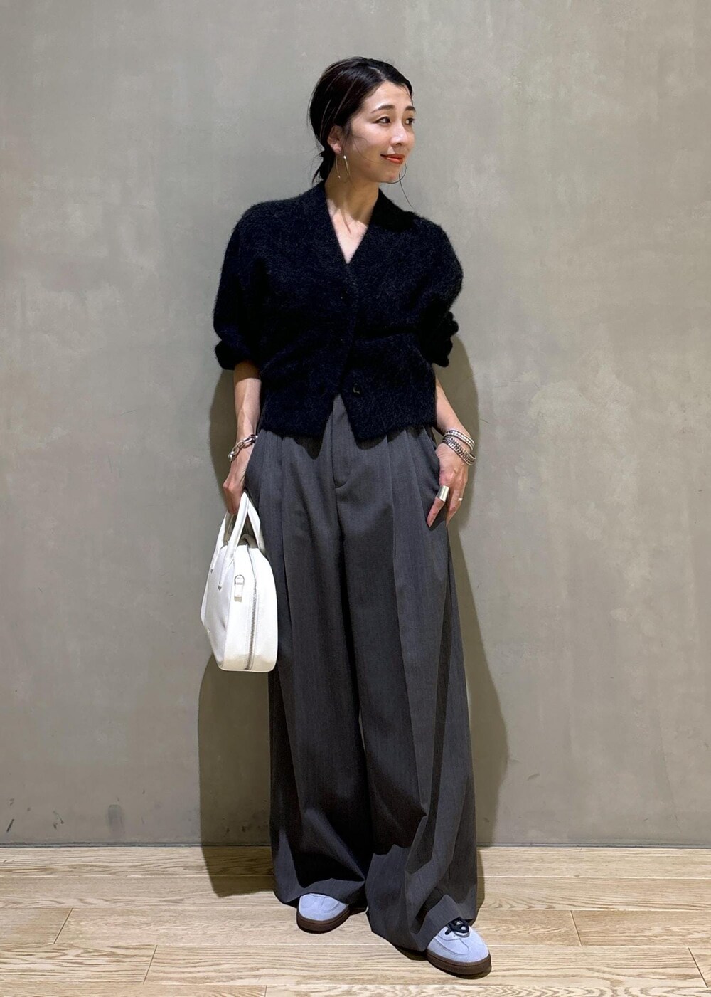 ホワイト系のボストンバッグ、グレー系のカーディガン/ボレロ、ブルー系のスニーカーを着用したレディースの秋コーディネートの2枚目の写真