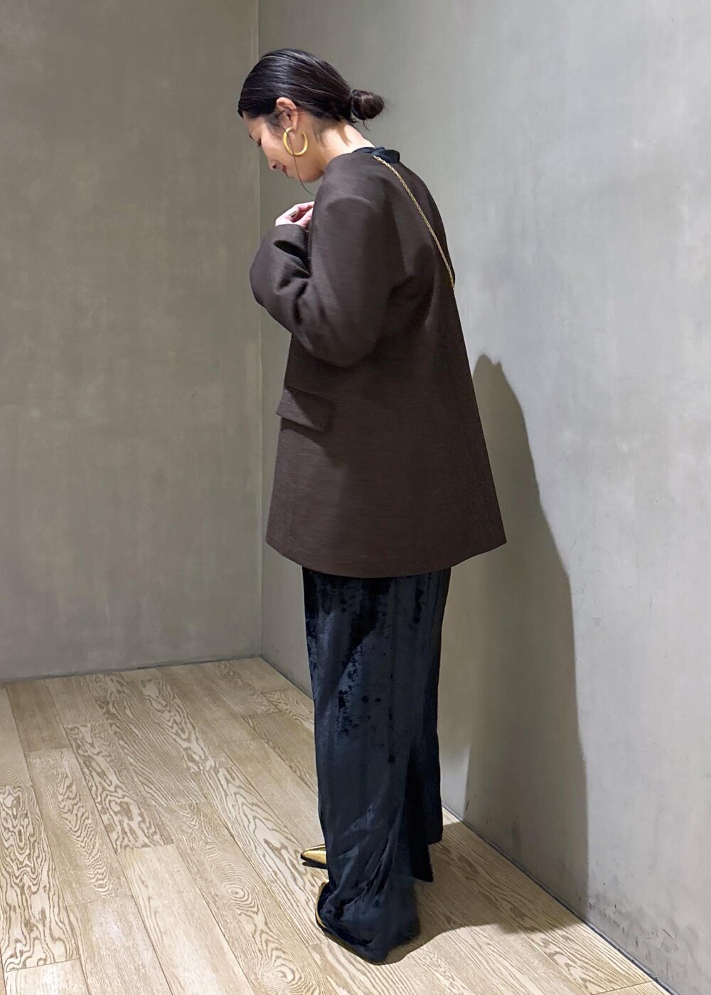 ブラック系のスカート、ブラック系のTシャツ/カットソー、ゴールド系のブーツを着用したレディースの冬コーディネートの7枚目の写真