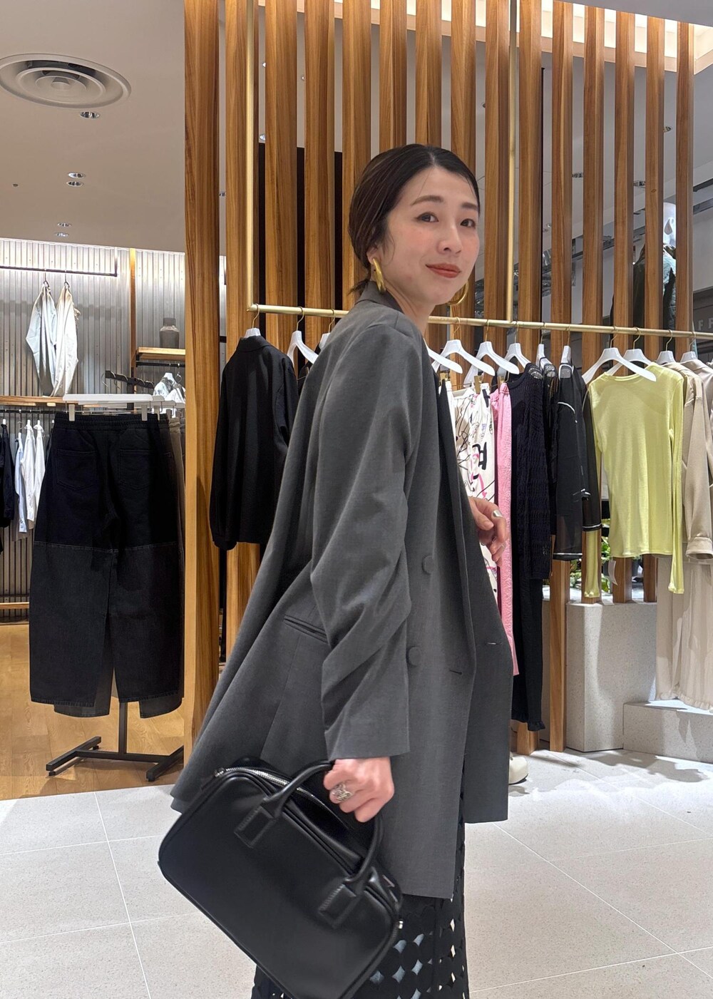 ブルー系のデニムパンツ、グレー系のテーラードジャケット、ブラック系のローファーを着用したレディースの春コーディネートの8枚目の写真