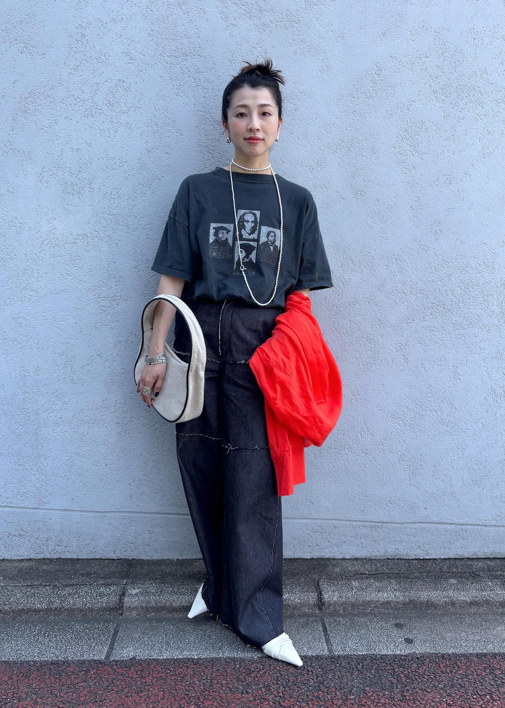 レッド系のシャツ/ブラウス、ブルー系のデニムパンツ、ホワイト系のハンドバッグを着用したレディースの夏コーディネートの2枚目の写真