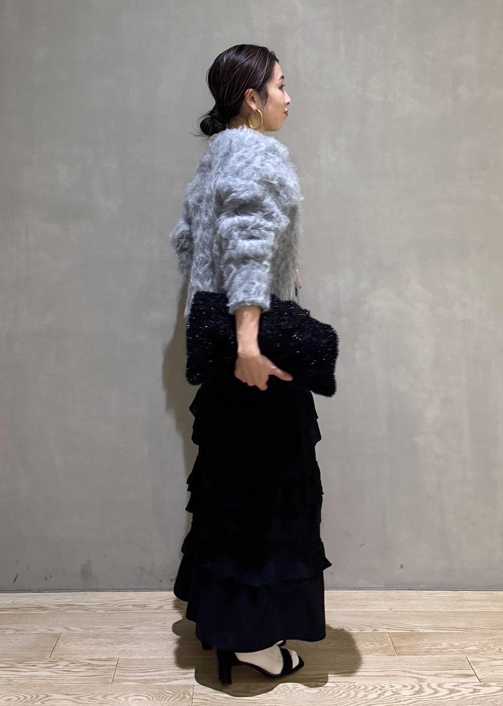 ブラック系のスカート、グレー系のカーディガン/ボレロ、ブラック系のトートバッグを着用したレディースの冬コーディネートの4枚目の写真