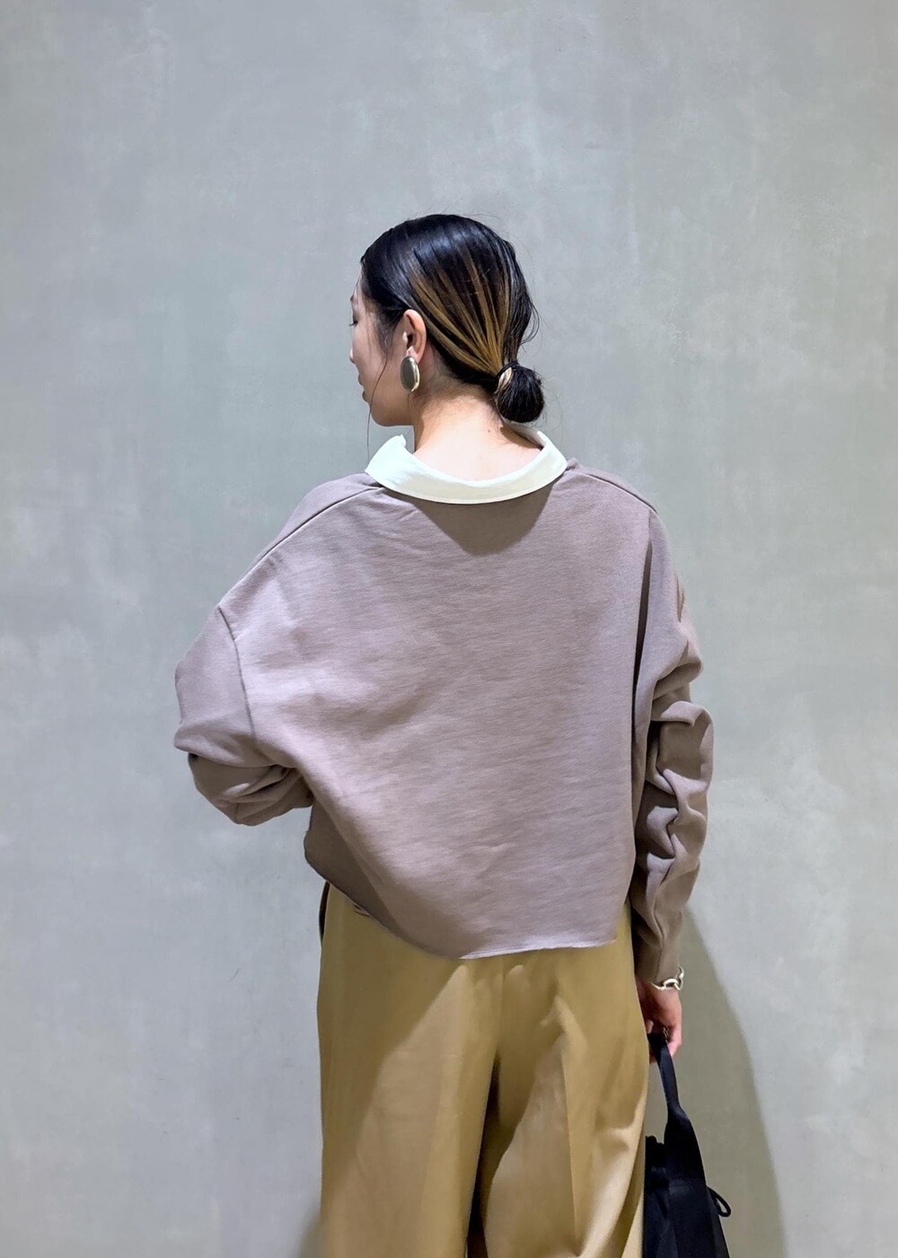 ブラック系のハンドバッグ、ブラウン系のサンダル、ベージュ系のTシャツ/カットソーを着用したレディースの秋コーディネートの6枚目の写真