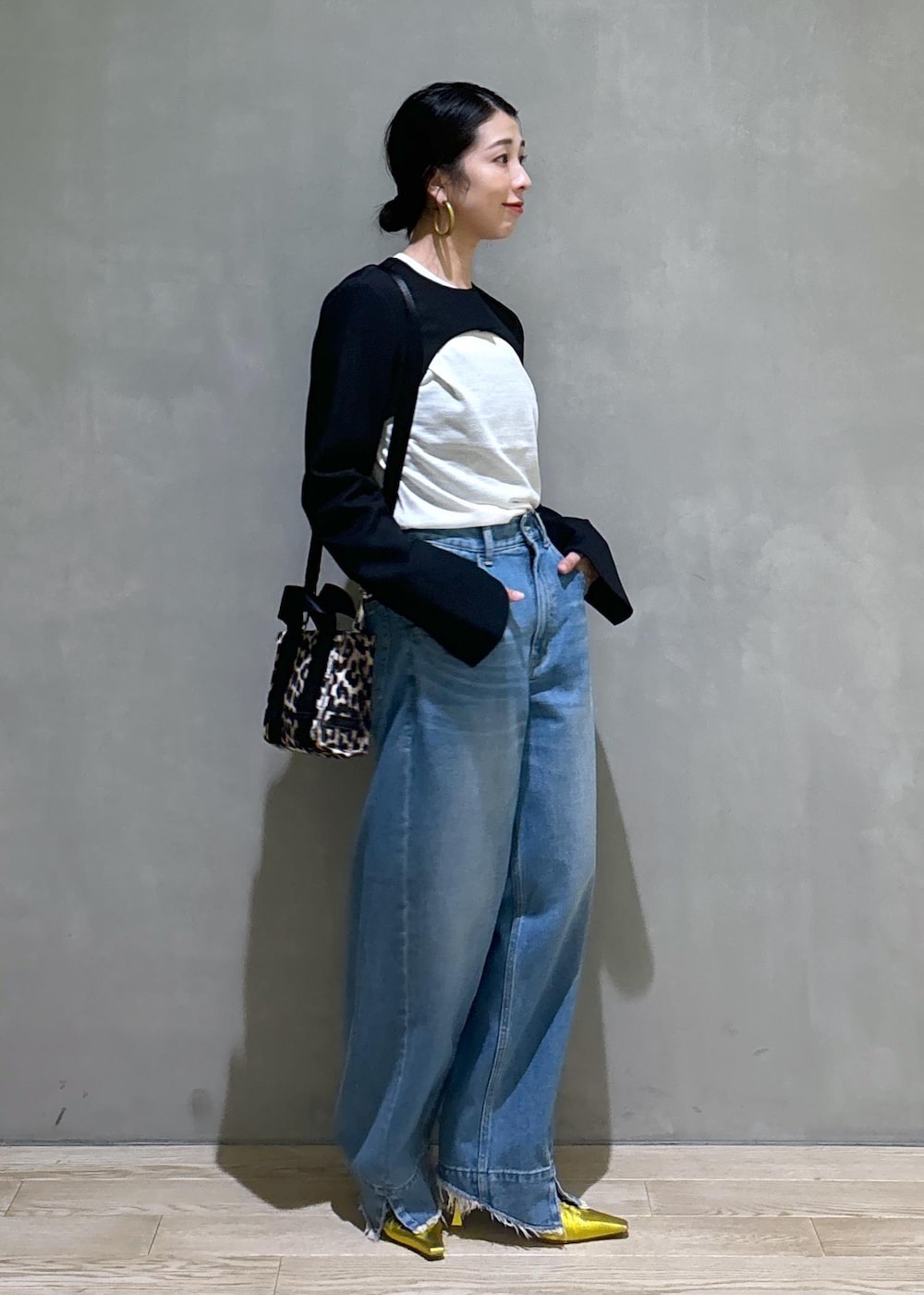 ブルー系のデニムパンツ、ゴールド系のパンプス、ブラック系のノーカラージャケットを着用したレディースの秋コーディネートの10枚目の写真