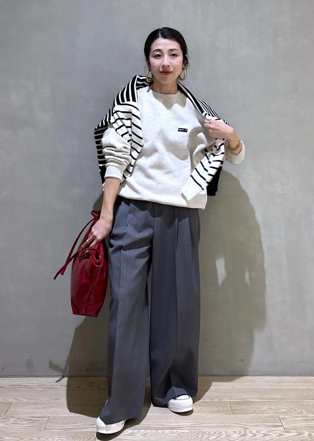 グレー系のスラックス、ホワイト系のスウェット、ブラック系のニット/セーターを着用したレディースの冬コーディネートの6枚目の写真