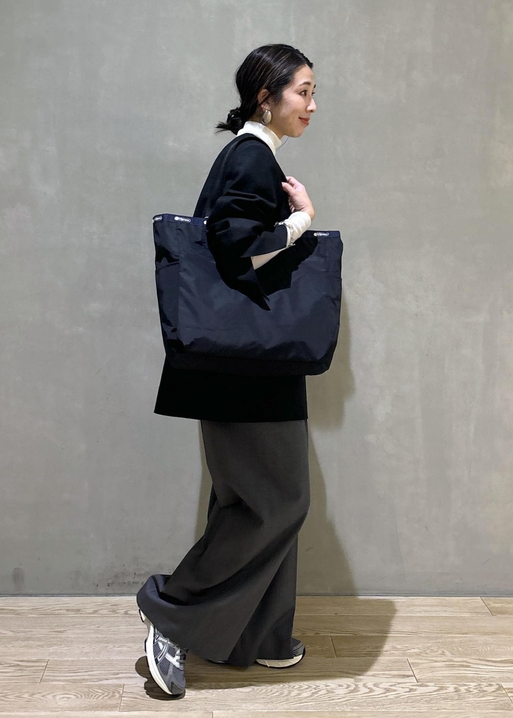 グレー系のスニーカー、ホワイト系のニット/セーター、ブラック系のシャツ/ブラウスを着用したレディースの秋コーディネートの5枚目の写真