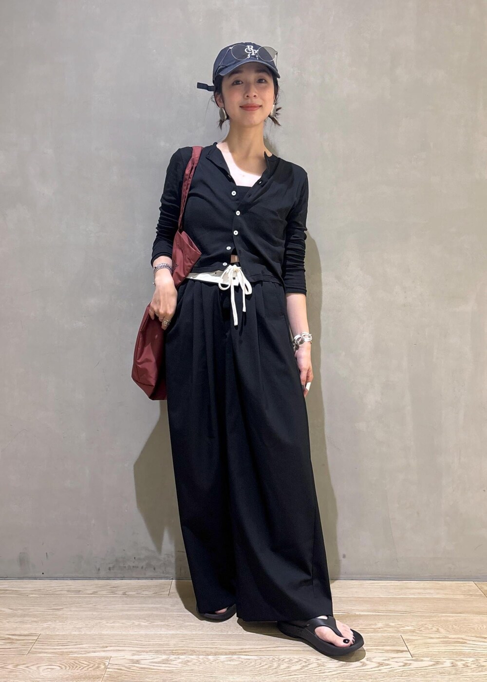 ブラック系のカーディガン/ボレロ、ブラック系のスラックス、シルバー系のサングラスを着用したレディースの夏コーディネートの2枚目の写真