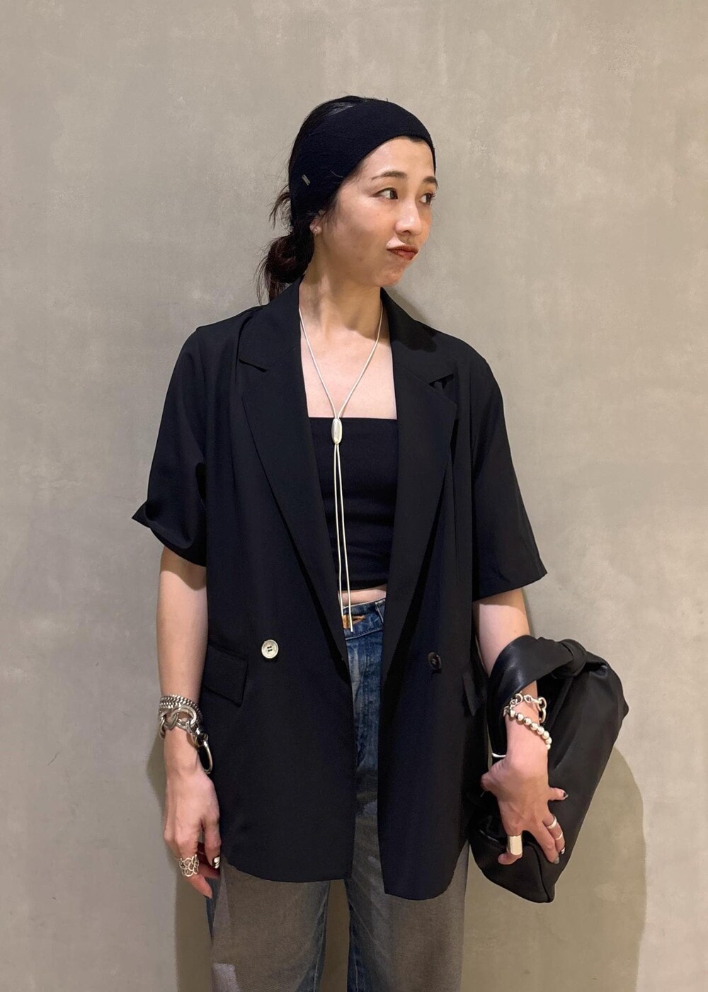 ブラック系のシャツ/ブラウス、ブルー系のデニムパンツ、シルバー系のネックレスを着用したレディースの夏コーディネートの10枚目の写真