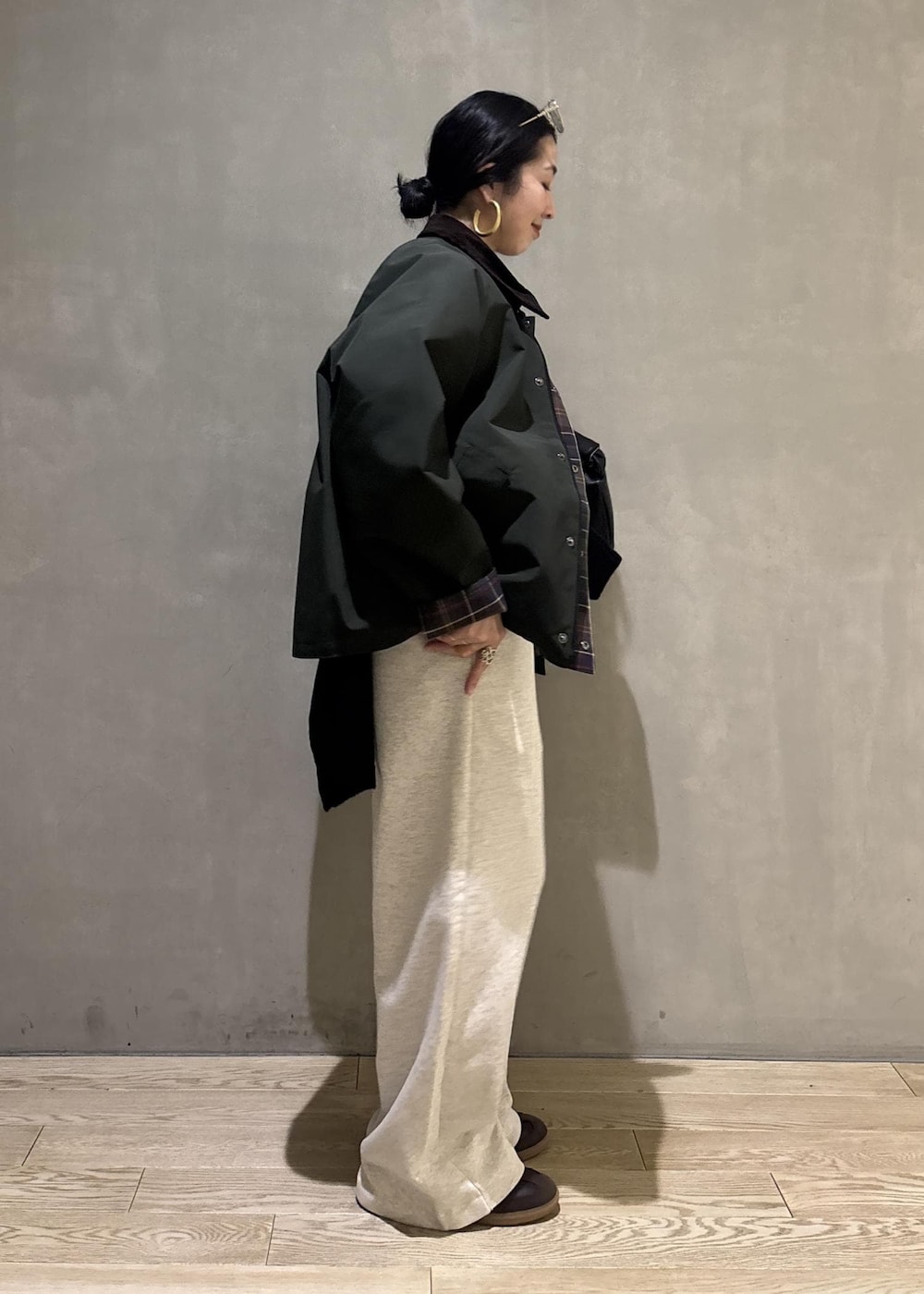 ブラック系のハンドバッグ、グリーン系のその他アウター、ホワイト系のその他パンツを着用したレディースの冬コーディネートの3枚目の写真