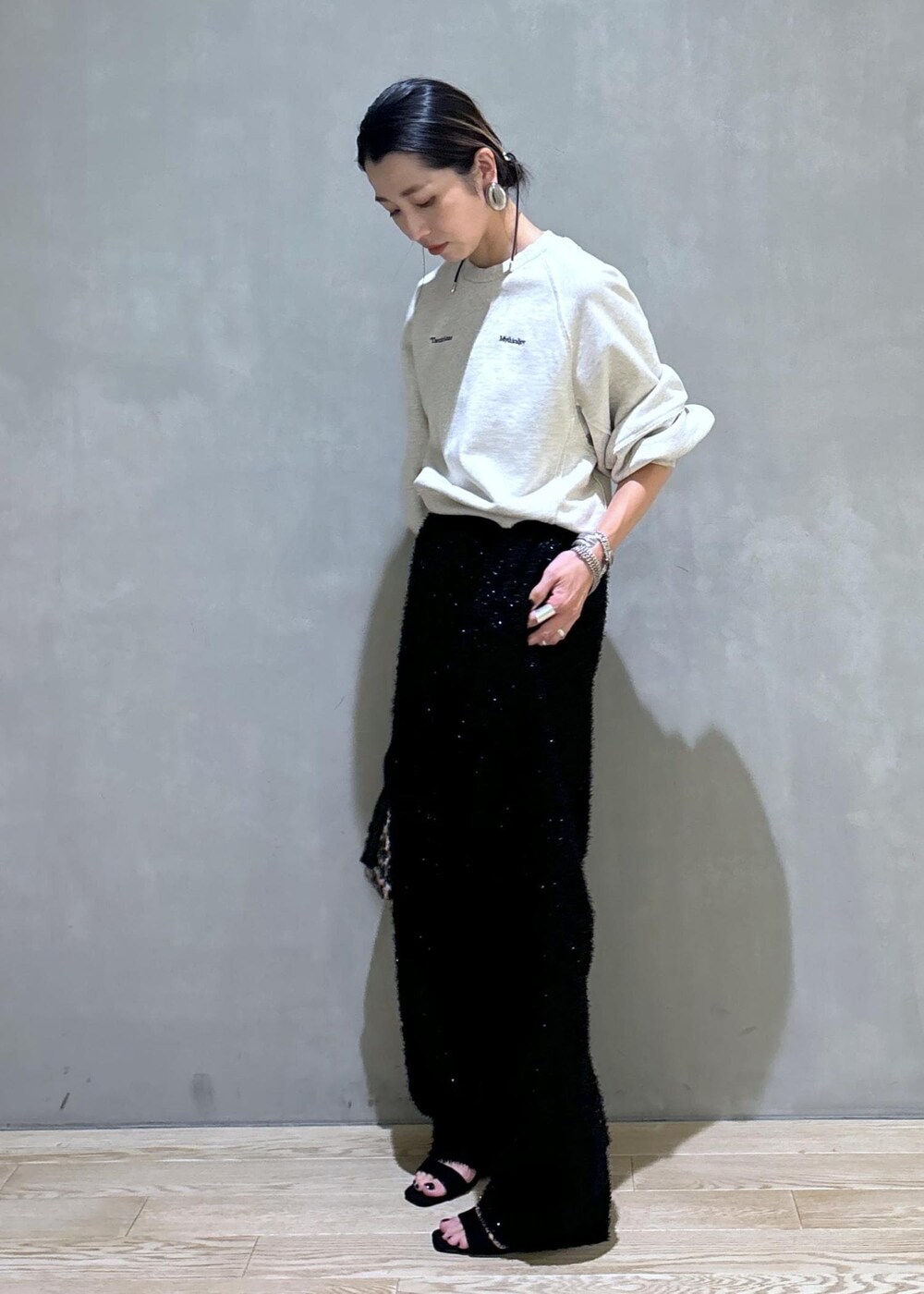 ブラウン系のハンドバッグ、ブラック系のその他パンツ、ホワイト系のスウェットを着用したレディースの夏コーディネートの4枚目の写真