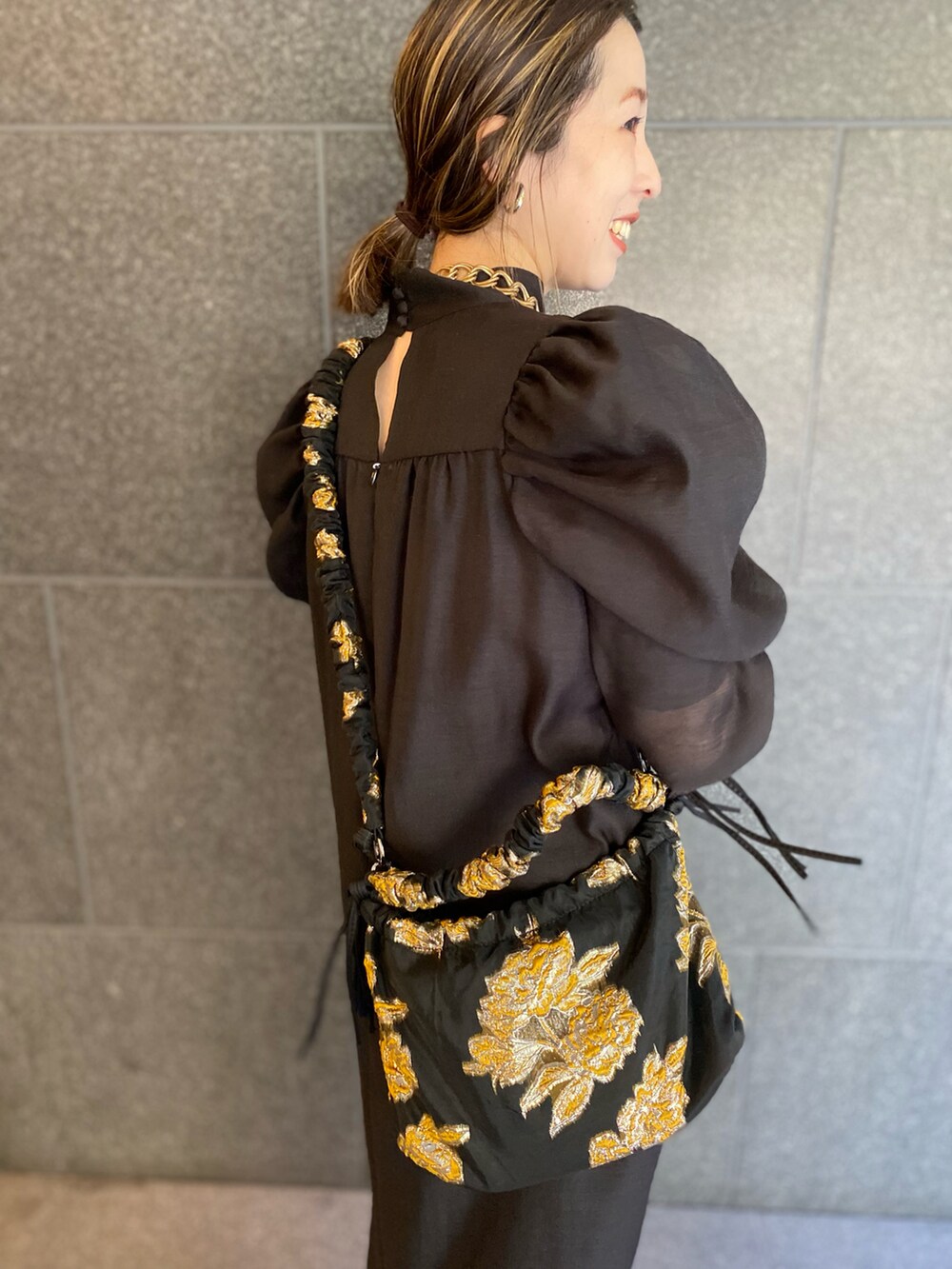 ブラック系のブーツ、ブラック系のワンピース、ブラック系のバッグを着用したレディースの春コーディネートの3枚目の写真