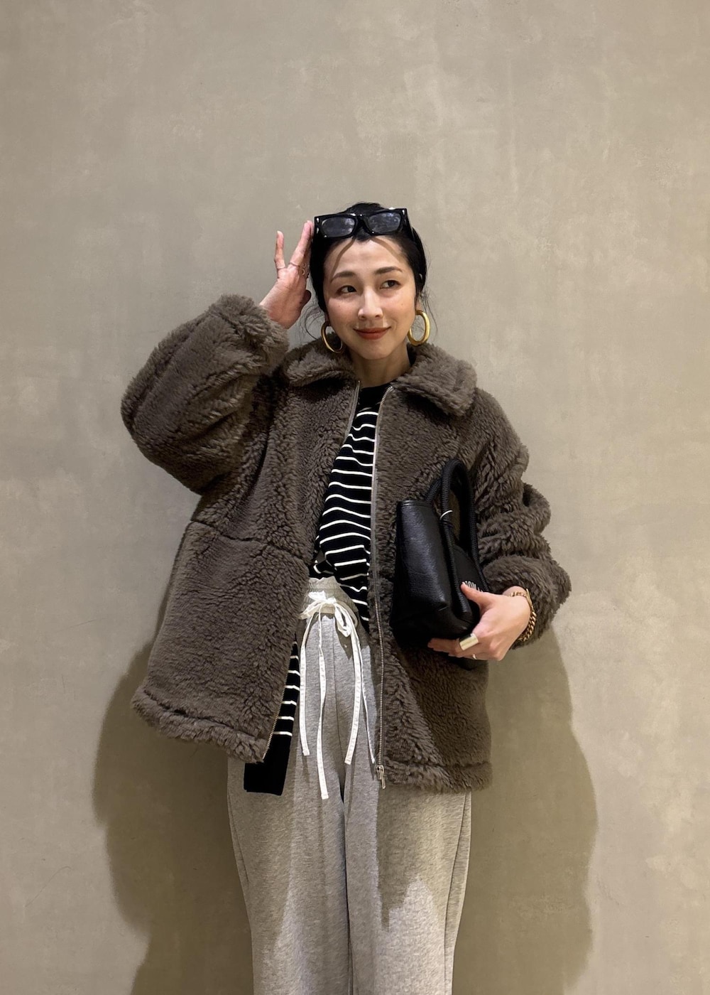 グリーン系のブルゾン、グレー系のその他パンツを着用したレディースの冬コーディネートの8枚目の写真